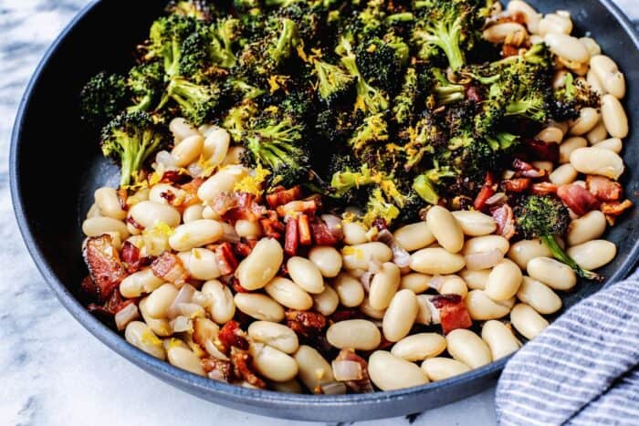 skillet with white beans, roasted broccoli, fried bacon, and lemon 