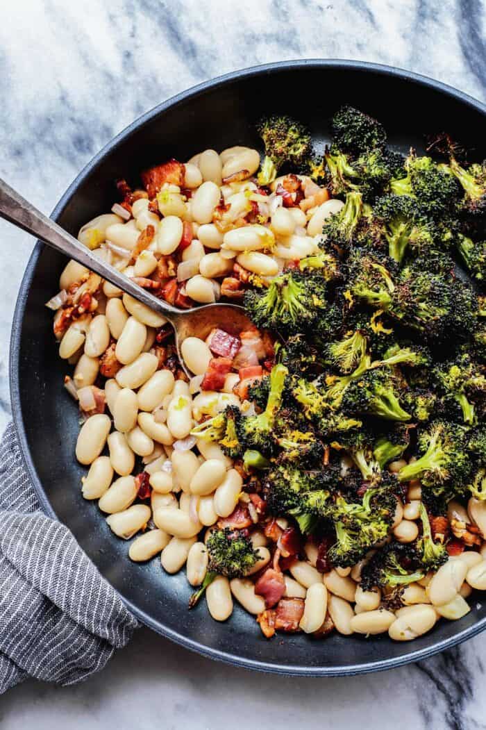 skillet with white beans, roasted broccoli, fried bacon, and lemon 