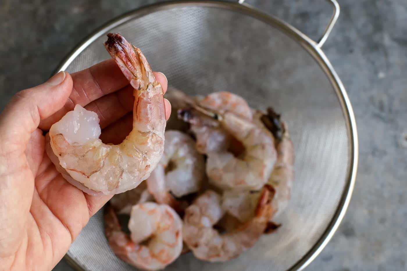 Flavorful margarita grilled shrimp kabobs are charred to perfection. This grilled shrimp recipe is perfect for summer dinners and appetizers! Jumbo shrimp in palm of hand to show its large size.
