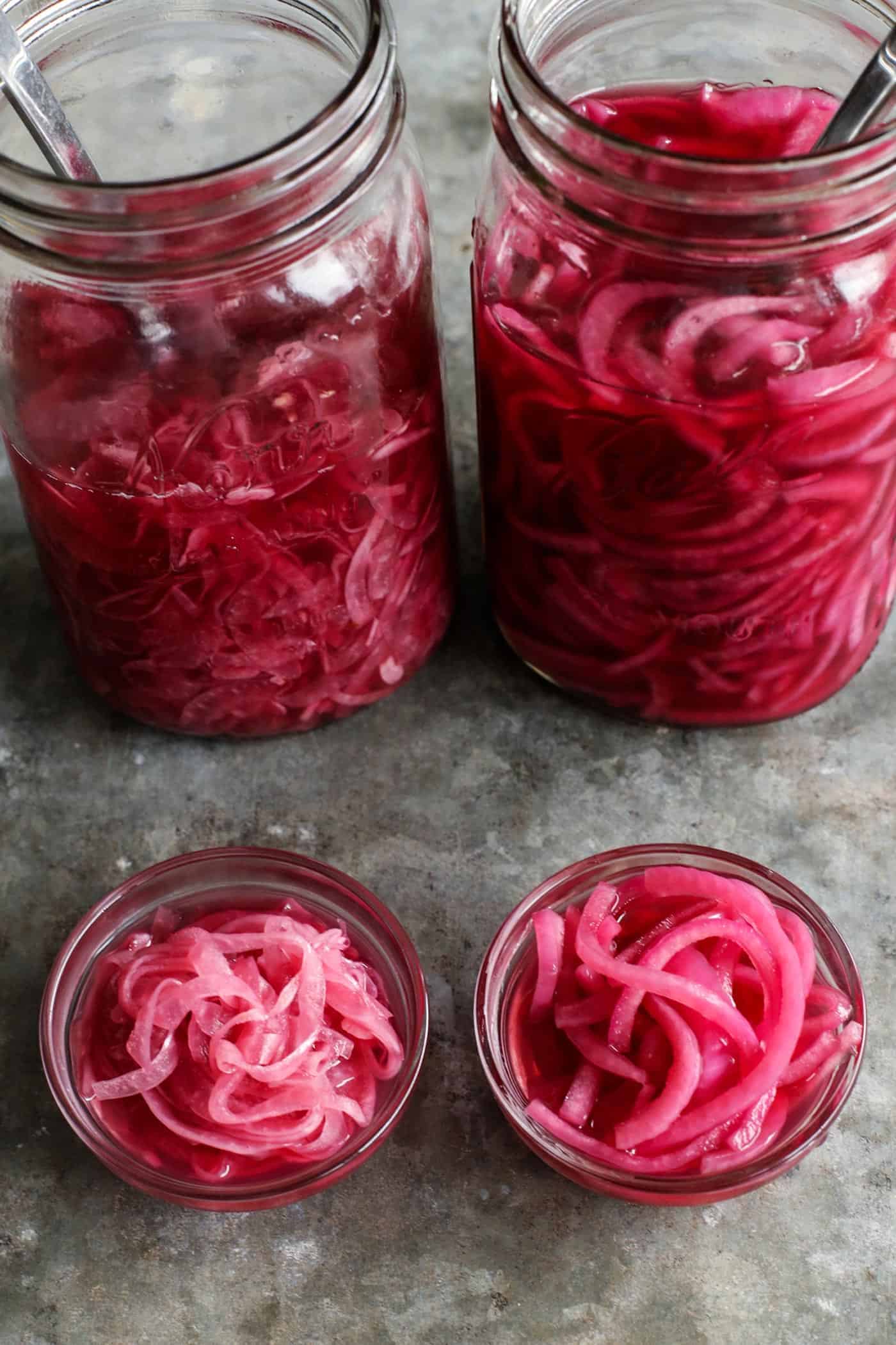 two jars of pickled red onions, 1 jar is thin-cut and the other jar is thick-cut