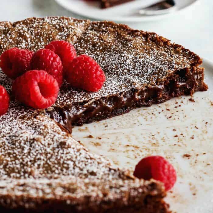 Szwedzkie ciasto czekoladowe przekrojone tak, aby odsłonić lepkie, kleiste wnętrze.