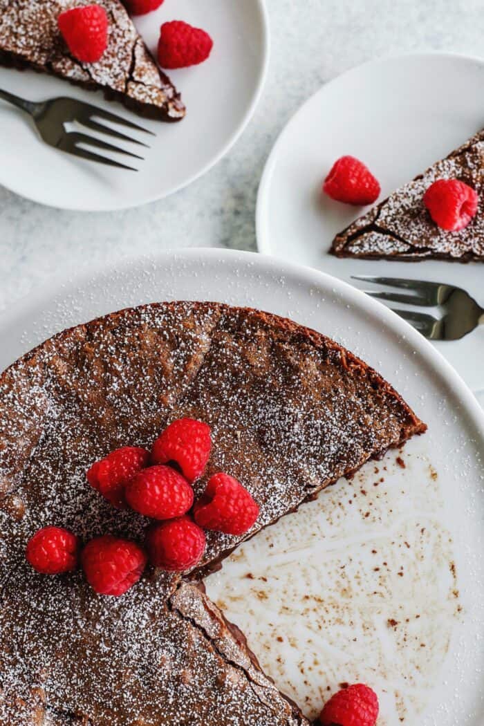 torta al cioccolato svedese su un piatto da torta, con due pezzi rimossi su piatti individuali