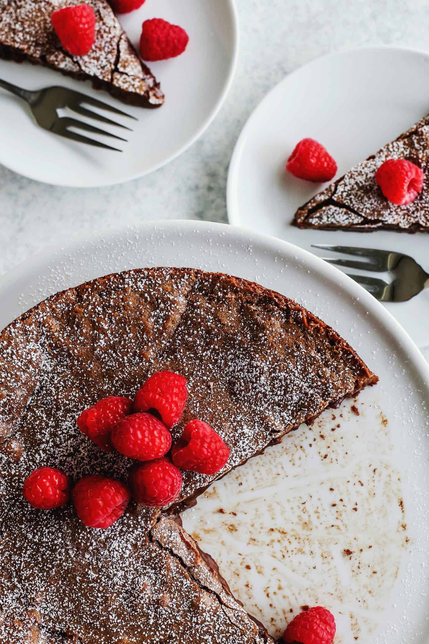 swedish chocolate cake on a cake platter, with two pieces removed onto individual plates