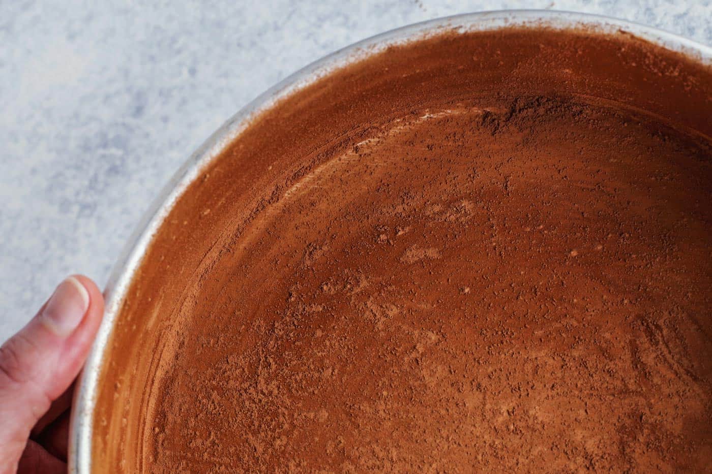 a pan that has been buttered and then dusted with cocoa powder, prepared for baking a chocolate cake