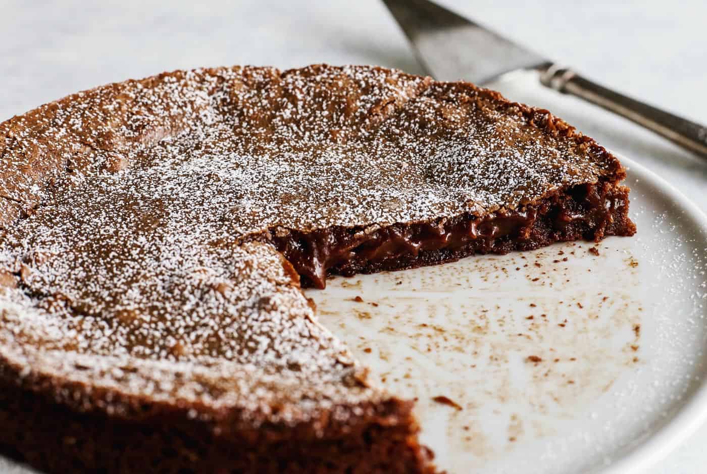 sticky, gooey Swedish chocolate cake on white pedestal cake platter
