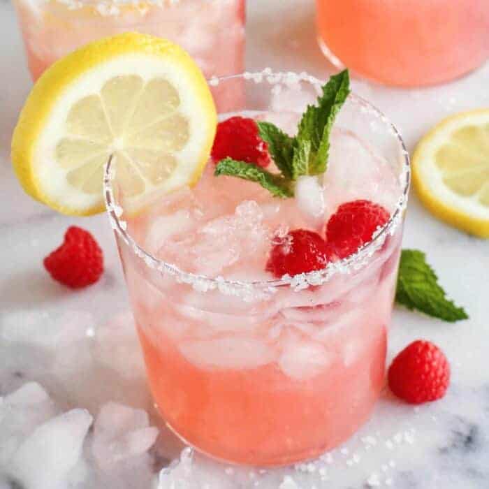 pink lemonade margarita with fresh lemon, raspberries, and mint