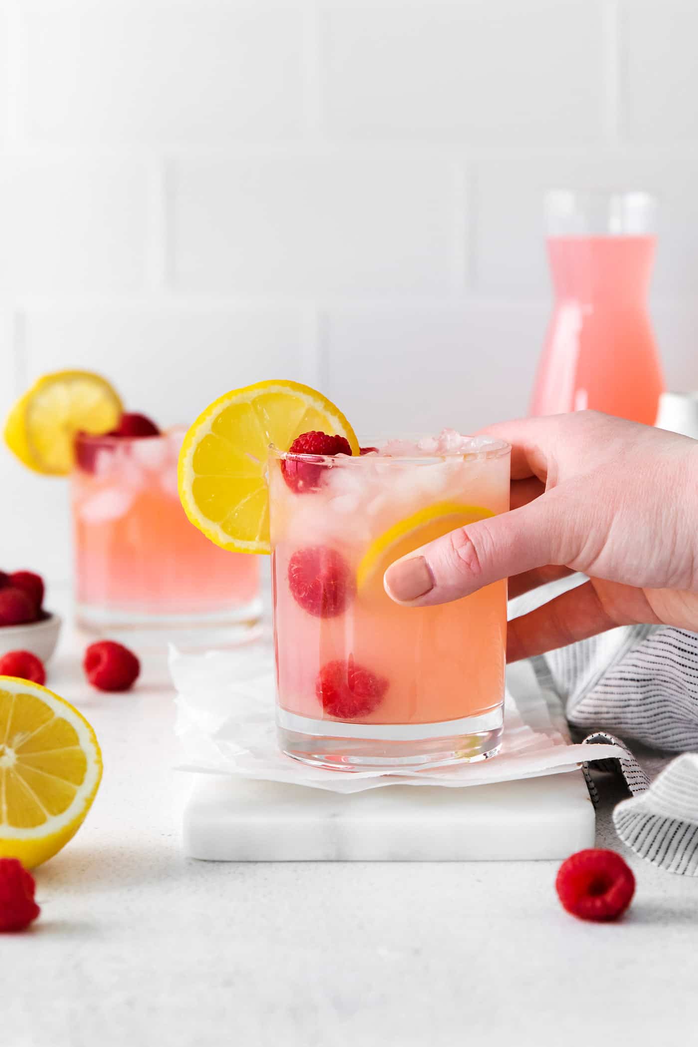 A hand holding a pink senorita cocktail
