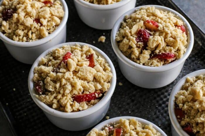 ramekins of rhubarb and strawberry crumble, ready to go into the oven