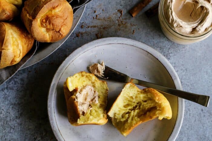 a popover on a plate with honey butter