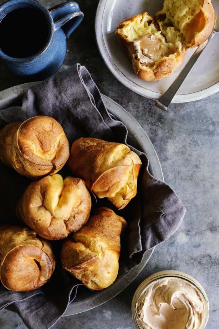 basket of popovers, mug of coffee, and jar of cinnamon honey butter