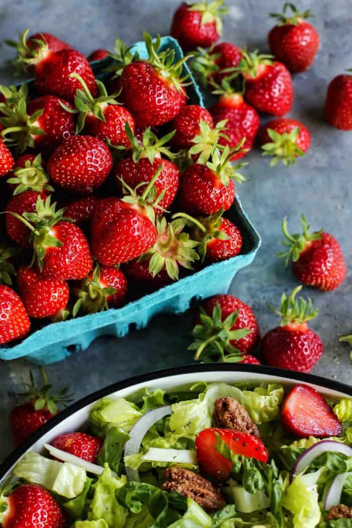 an aqua market container full of fresh strawberries