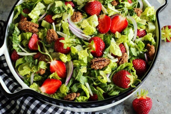 big bowl of fresh salad of chopped greens and strawberries