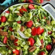 a box of ripe strawberries and strawberry salad in a large bowl