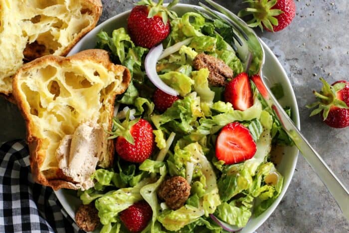 lettuce and strawberry salad on a plate, with a popover