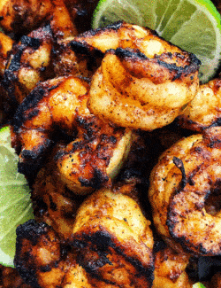 jumbo shrimp that is charred from grill, with fresh lime wedges