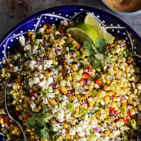 Mexican corn salad in a blue painted pottery bowl