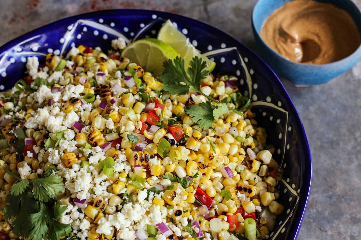 salad made with fresh sweet corn, in a blue pottery bowl