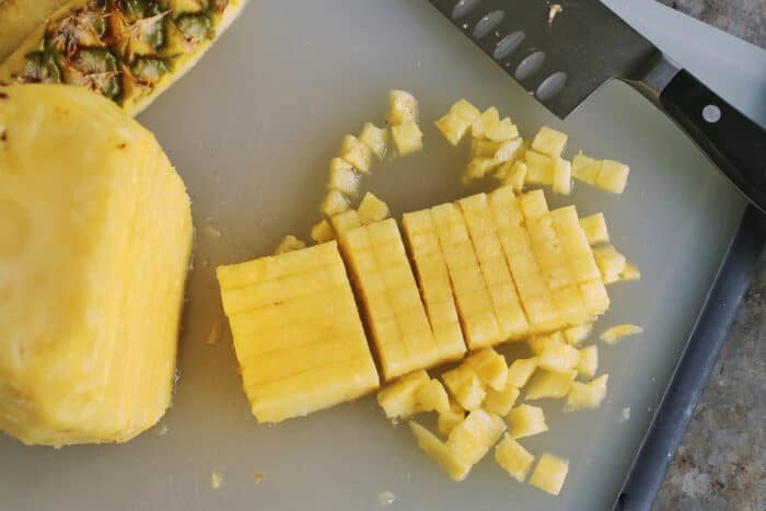 cutting slices of pineapple into small cubes