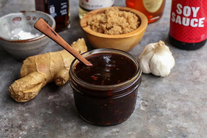 a jar of homemade teriyaki sauce, ginger, garlic, sesame oil, rice vinegar, honey, soy sauce, and cornstarch