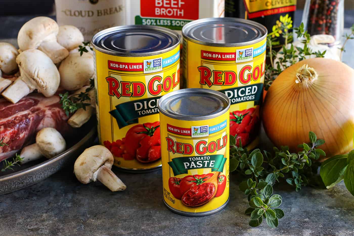 ingredients to make beef stew, including beef chuck roast and Red Gold canned tomato products