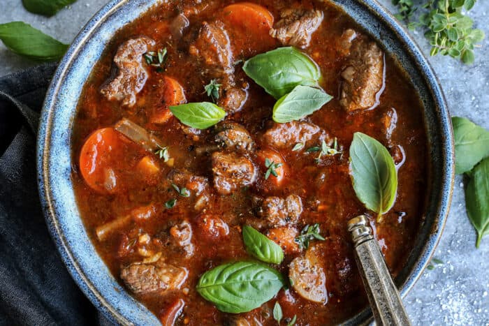 overhead photograph of beef stew with vegetables, in a beef and tomato based broth