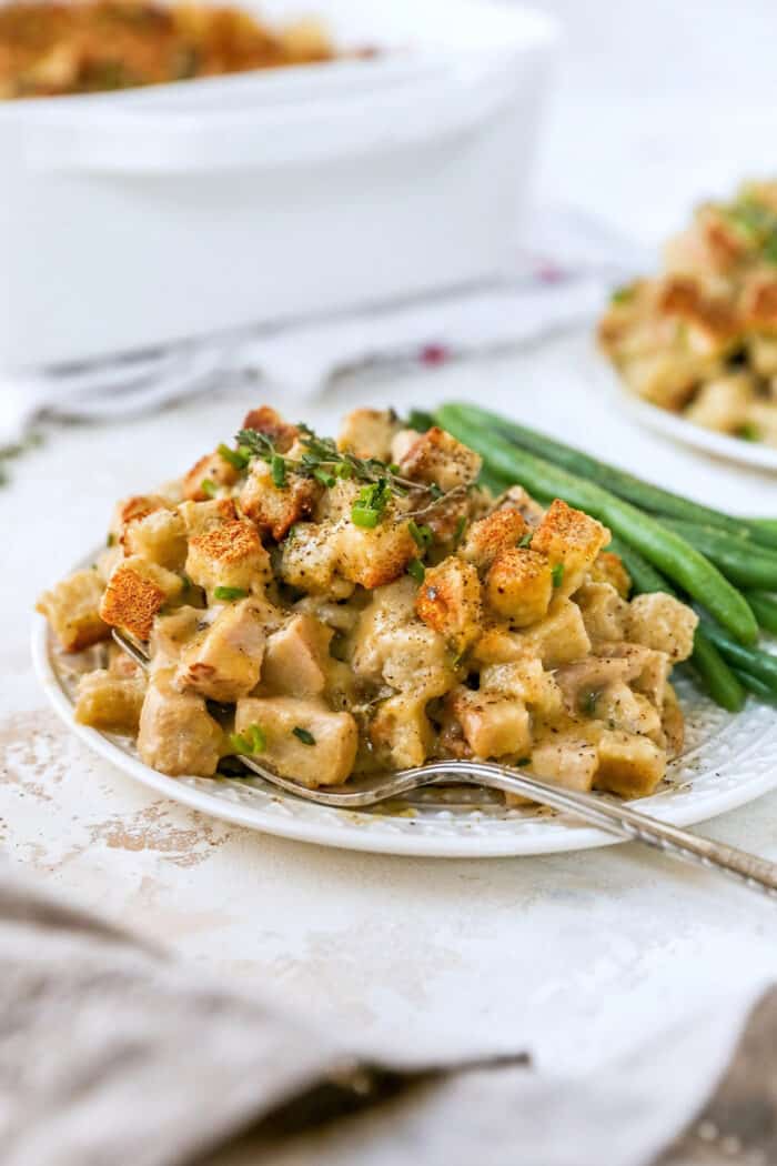 close up photo of casserole on a plate with green beans