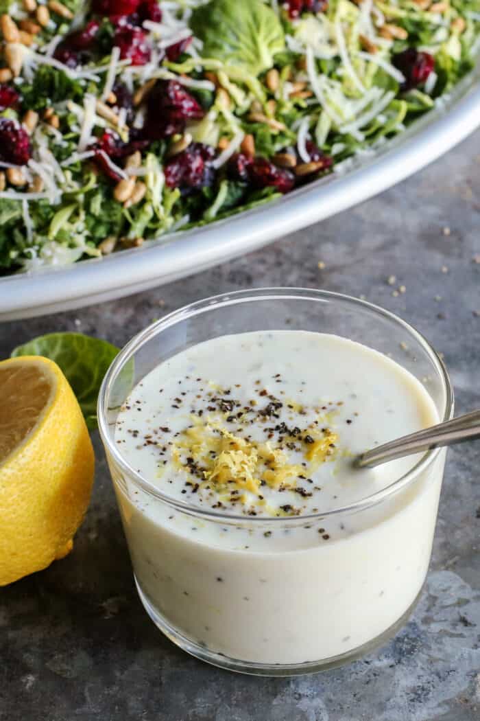 lemon yogurt dressing in a glass jar with salad in background