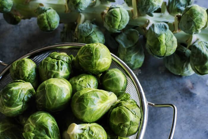 Brussels sprouts on the stalk and washed in a metal colander
