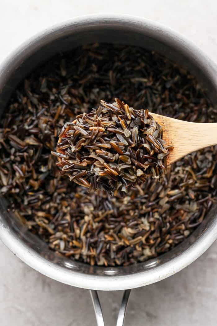 Close-up of wild rice on a wooden spoon.