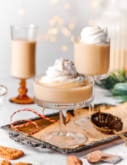 Three glasses of creamy Christmas eggnog with whipped cream.