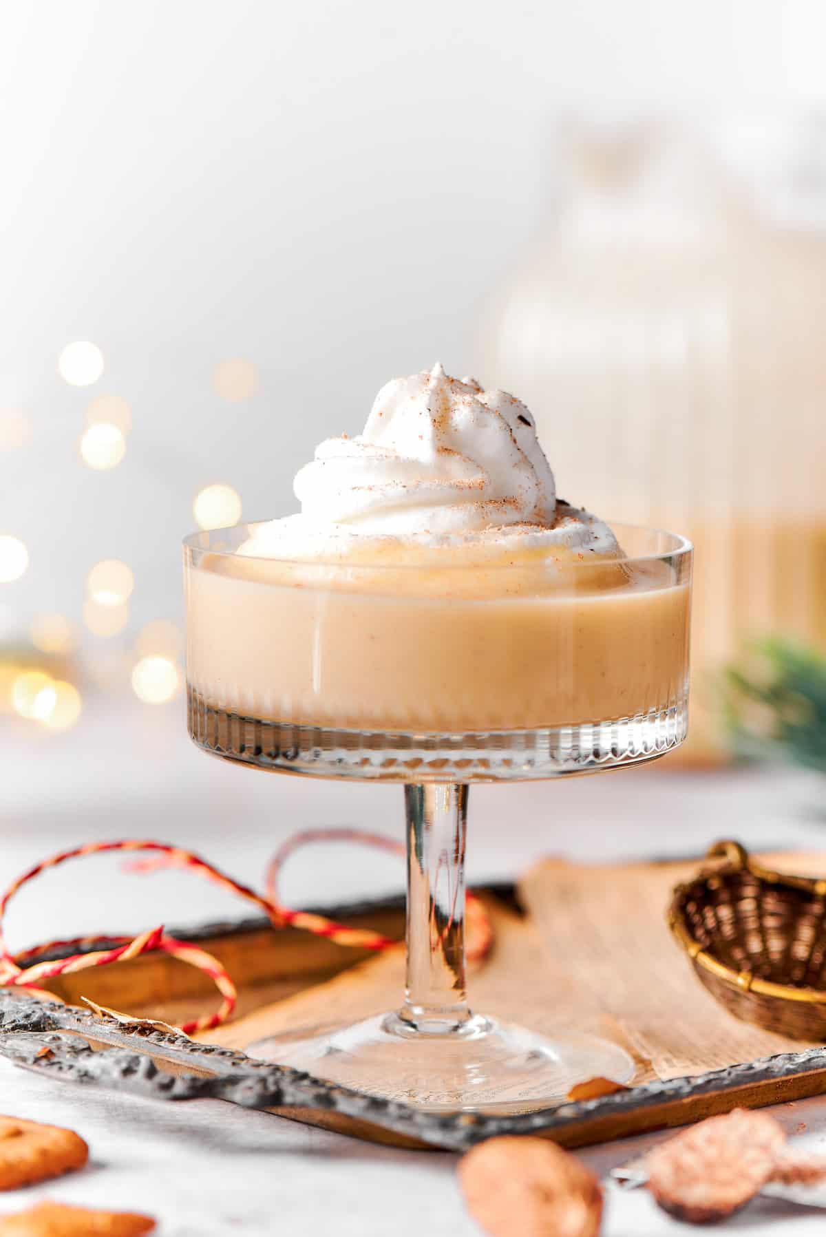 Close-up shot of rich spiced homemade eggnog with whipped cream on top. 