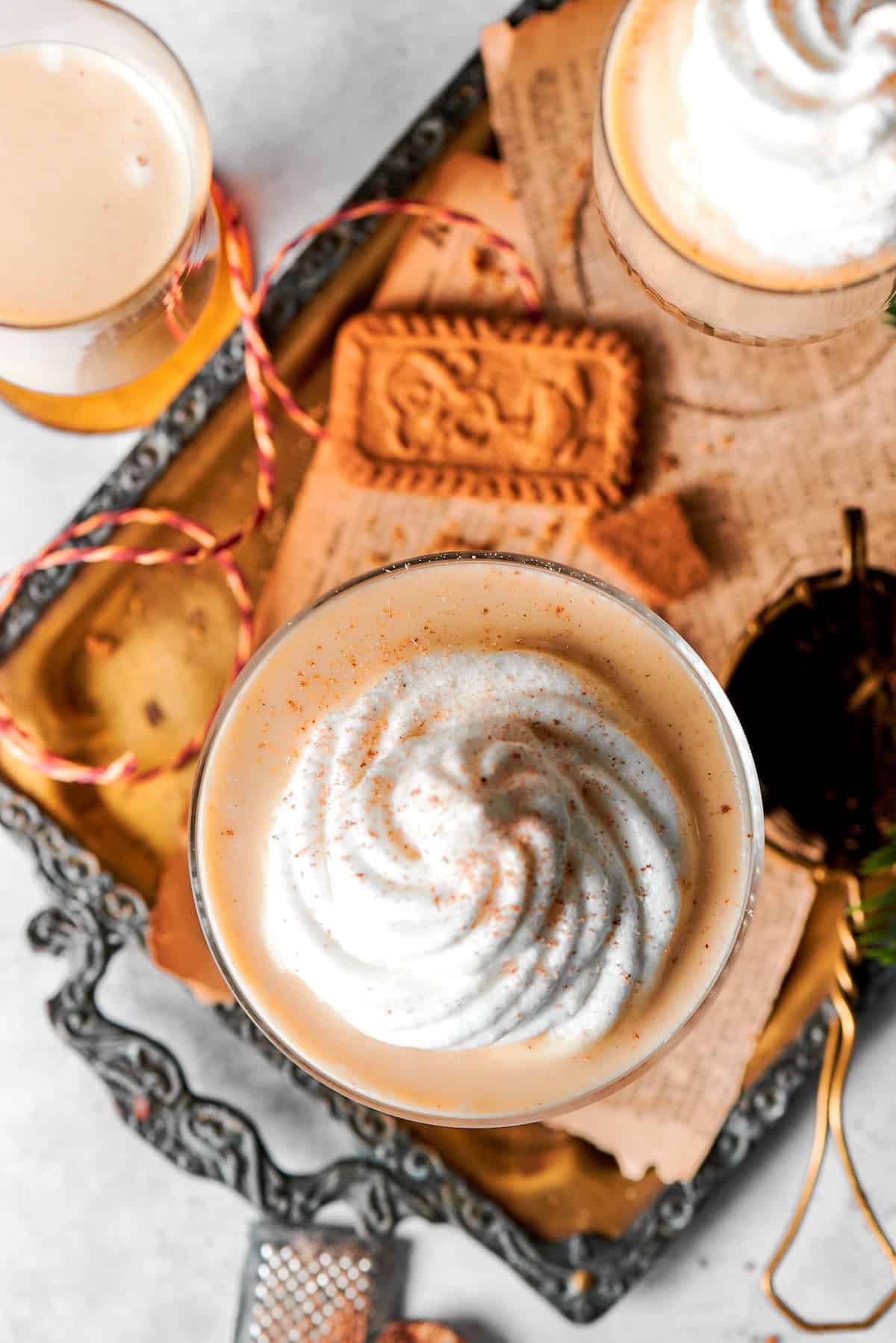 Overhead photo of creamy eggnog cocktail with whipped cream and nutmeg.