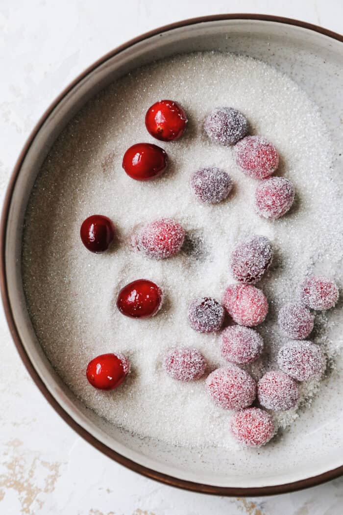 cranberries coated in simple syrup, rolled in sanding sugar in a small bowl