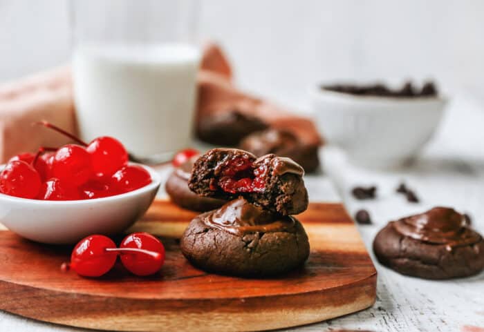 chocolate cookies with cherries inside and a small bowl of maraschino cherries