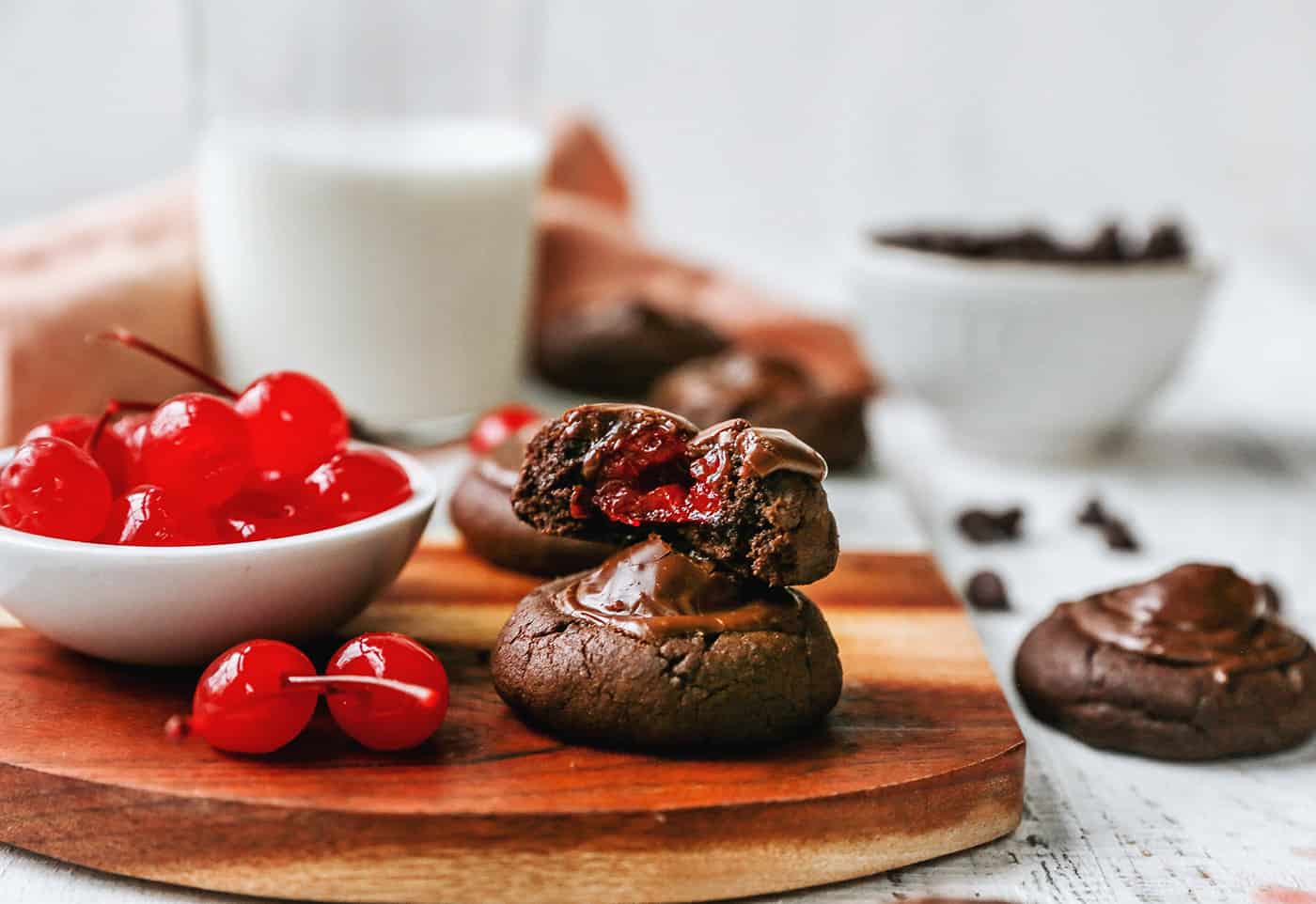 chocolate cookies with cherries inside and a small bowl of maraschino cherries