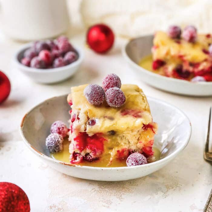 pieces of cranberry Christmas cake with butter cream sauce and sugared cranberries