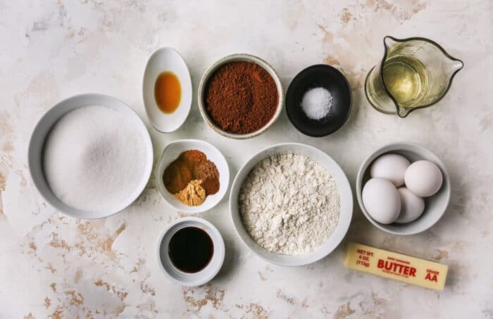 individual bowls and measuring cups with ingredients for brownies