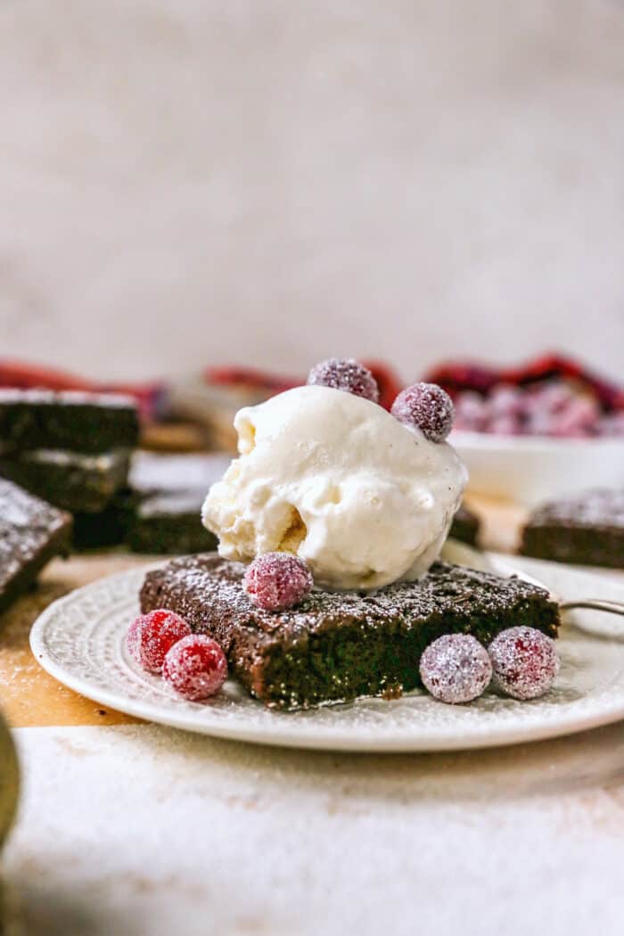 gingerbread brownie with a scoop of vanilla ice cream and sugared cranberries