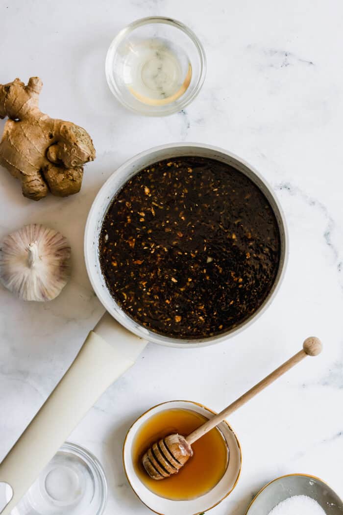 prepared oyster sauce in a pot with individual ingredients alongside