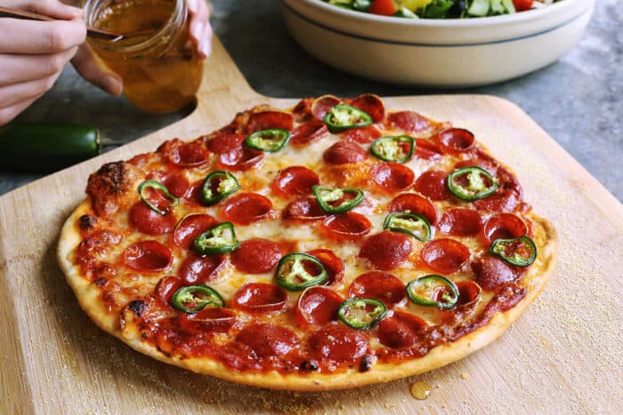 thin crust pizza with pepperoni, jalapeno, and honey