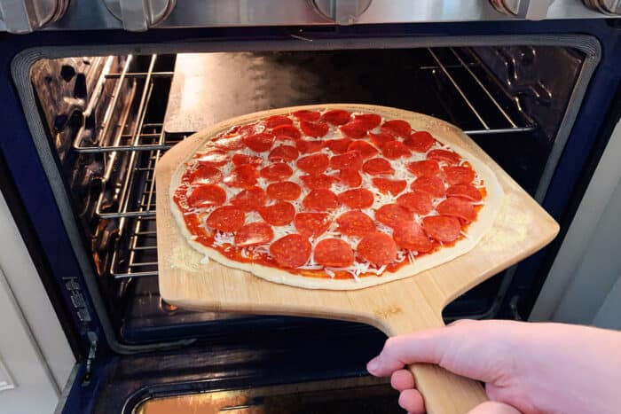 pizza on a pizza peel, going into the oven