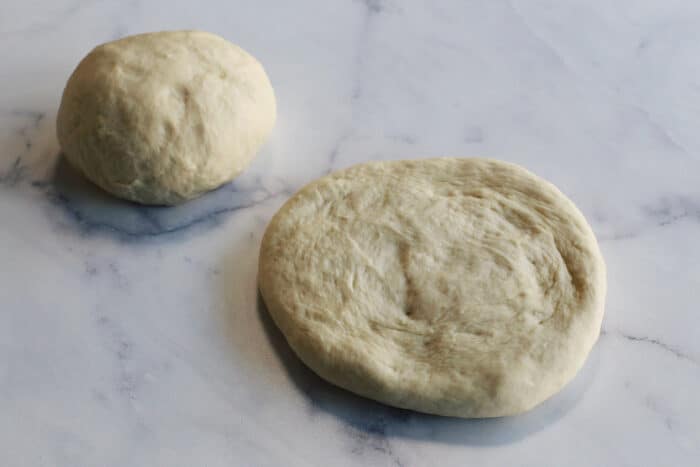 one round ball of dough, one flattened ball of dough