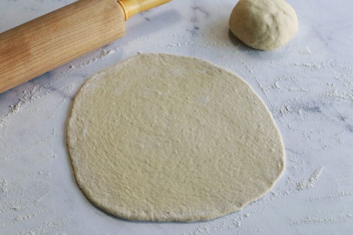 dough rolled out with a rolling pin, on white marble