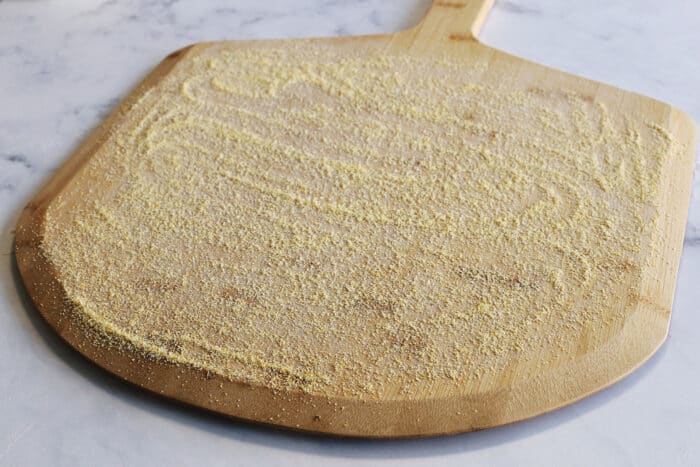 cornmeal on a wood pizza peel