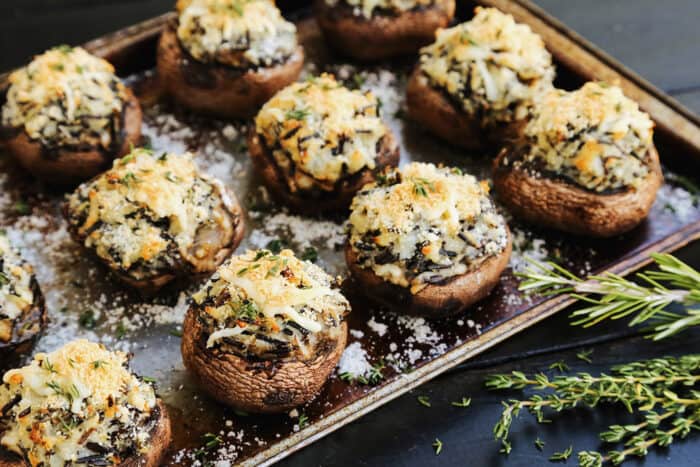 a sheet pan of baked stuffed mushrooms with mashed potato and wild rice filling