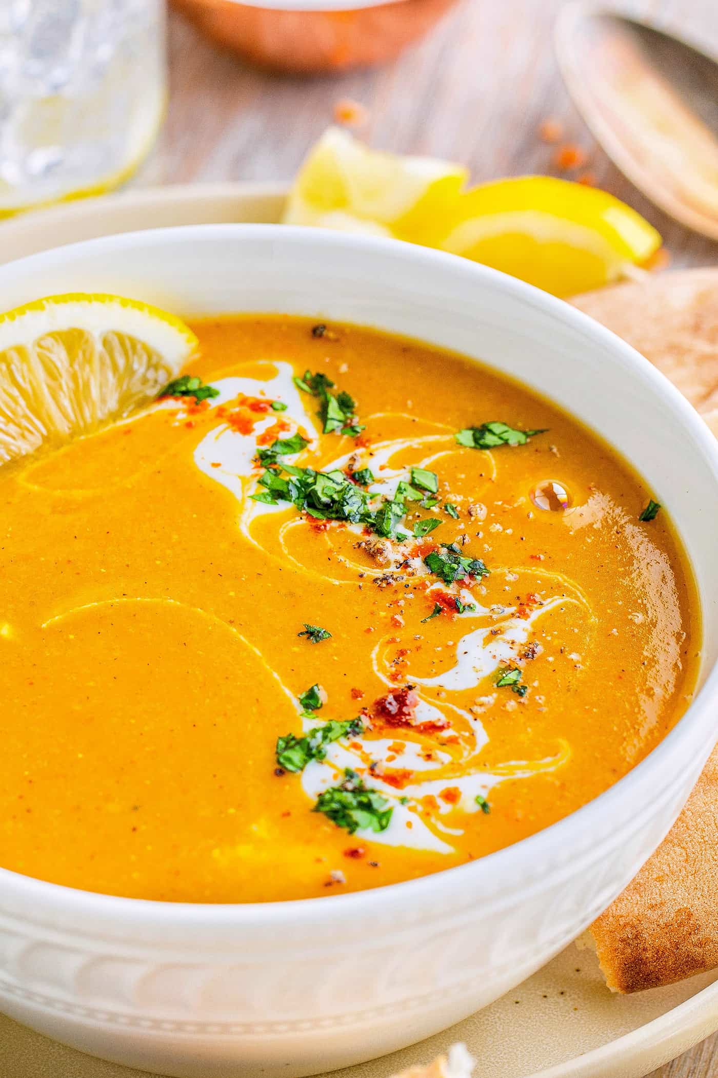 a blended soup made of red lentils and vegetables, in a white bowl