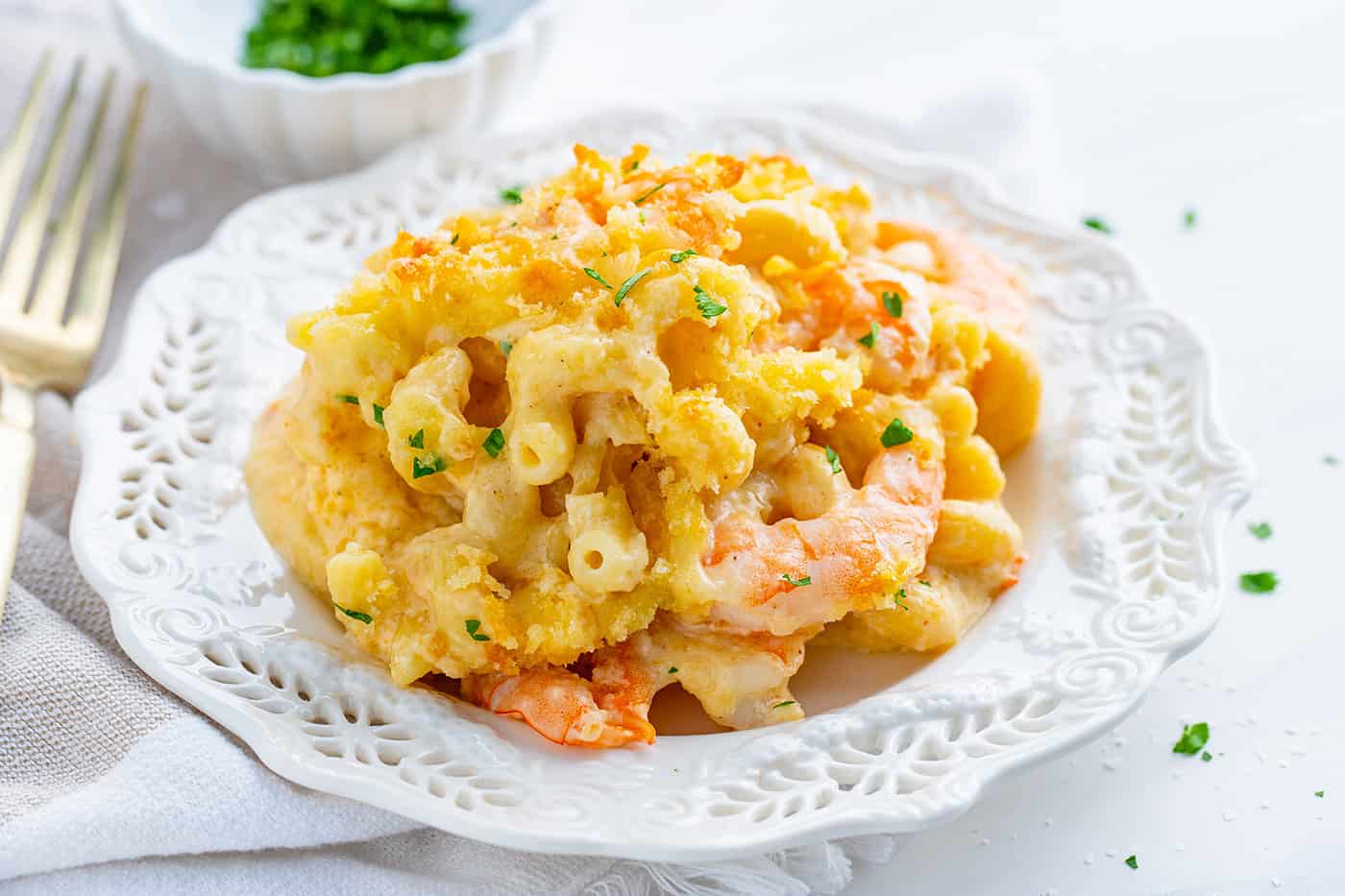a serving of baked macaroni and cheese with shrimp on a white plate