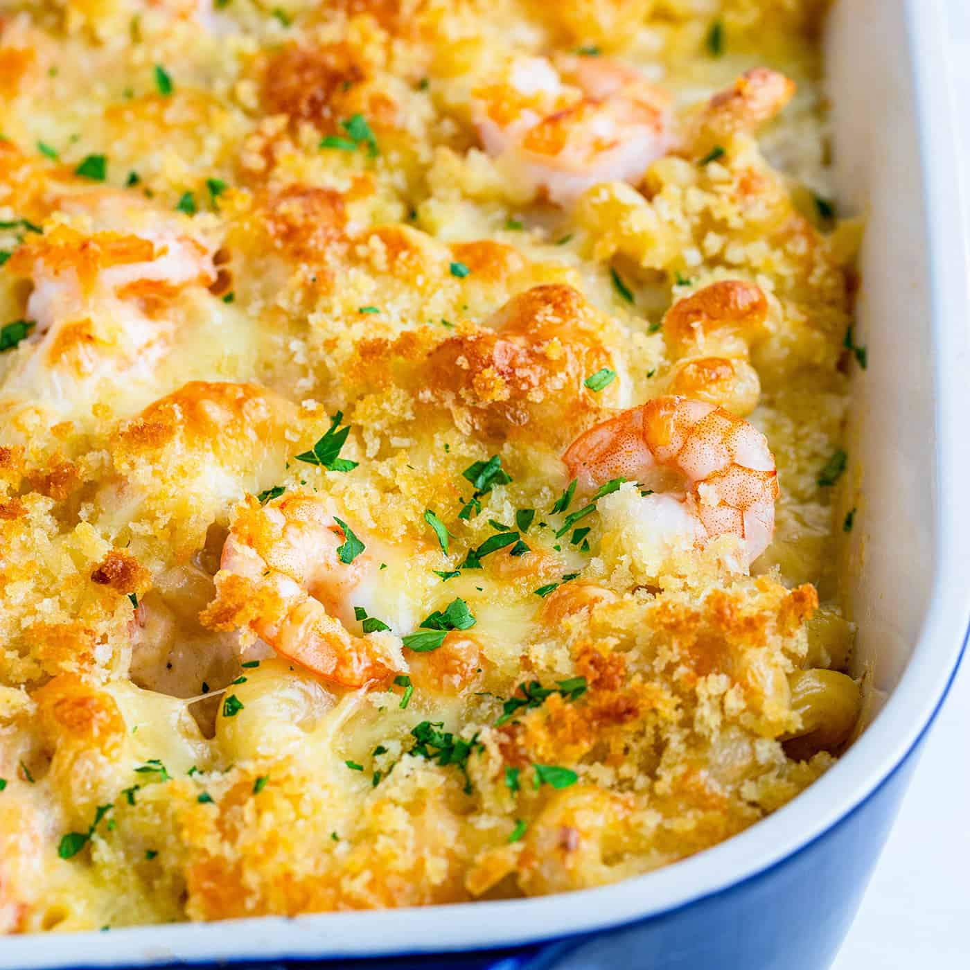 macaroni and cheese with shrimp, baked in a blue casserole dish