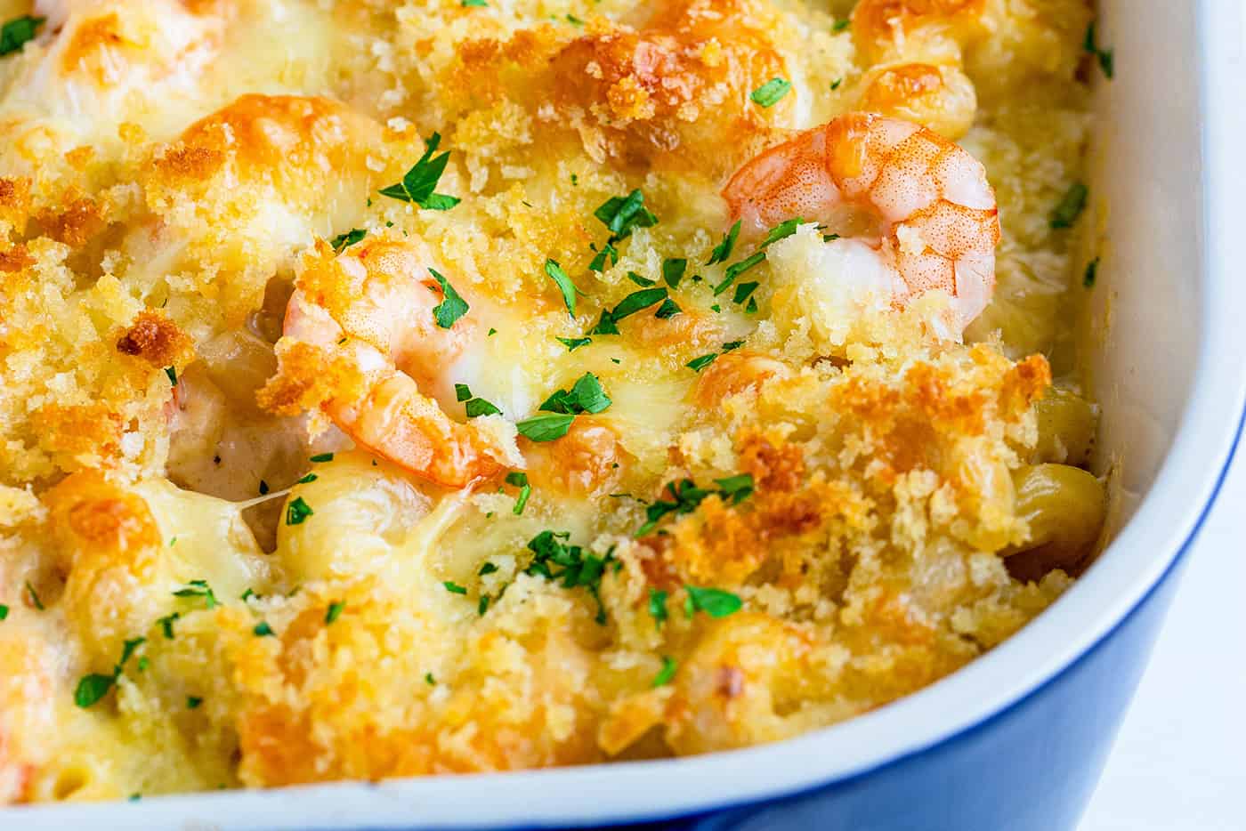 close-up photo of baked shrimp mac and cheese in a blue baking dish