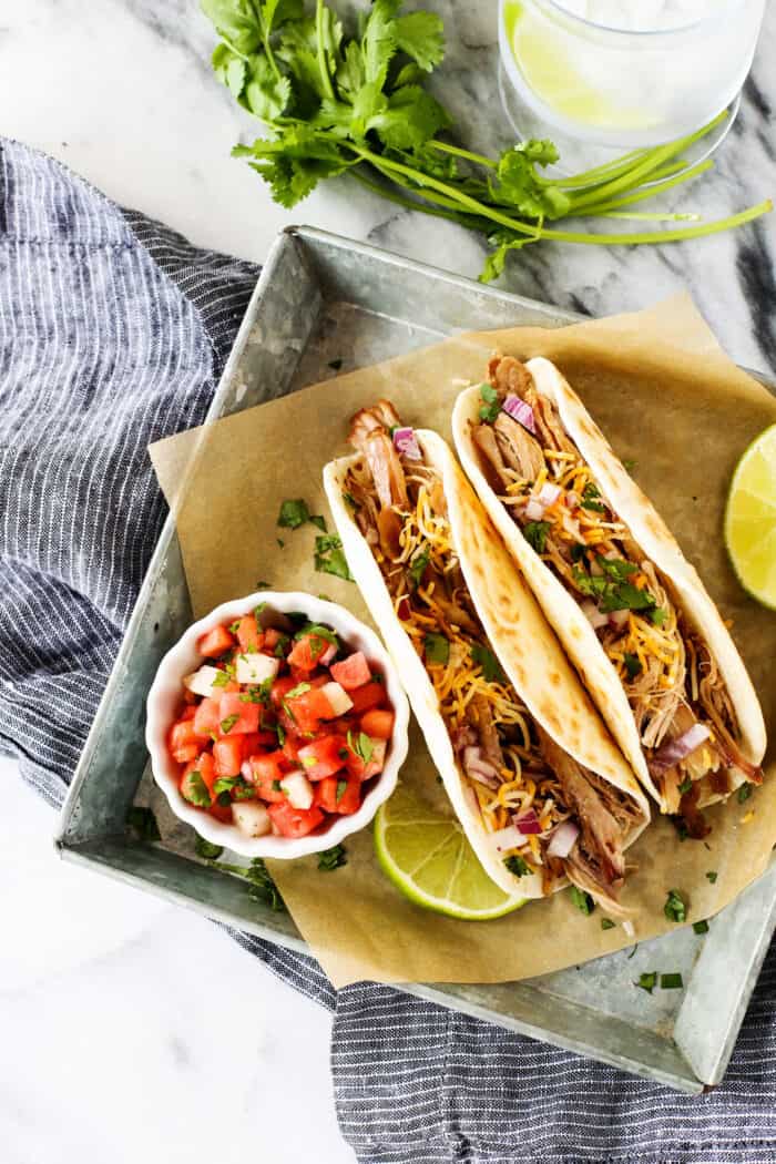 carnitas tacos with a cup of watermelon salsa